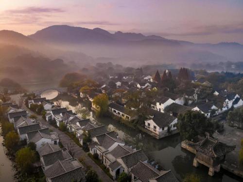 an aerial view of a village on a river with houses at Hotel Dayu Kaiyuan in Shaoxing