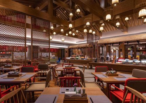 a restaurant with wooden tables and chairs and a bar at Hotel Dayu Kaiyuan in Shaoxing