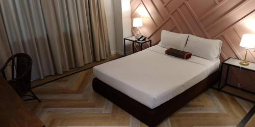 a bedroom with a white bed with a wooden headboard at The Regent Ubon in Ubon Ratchathani