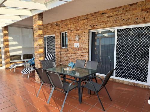 a table and chairs on a patio with a brick wall at Sea Breeze at Barrack Point in Barrack Point