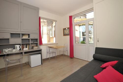 - un salon avec un lit, un bureau et une table dans l'établissement La Rosace, à Chartres