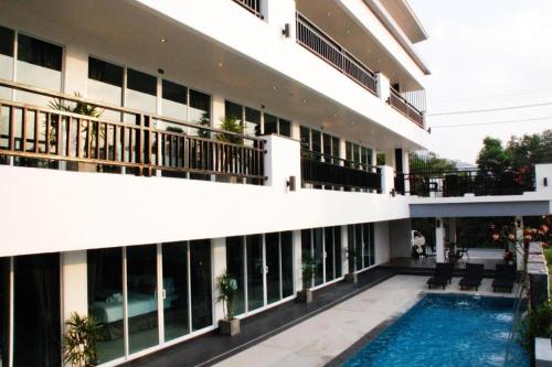 an external view of a building with a swimming pool at Amin Resort in Ban Thalat Choeng Thale