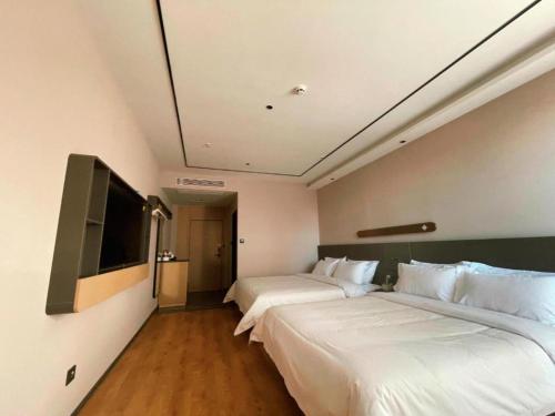 a hotel room with two beds and a flat screen tv at GreenTree Inn Datong YundinGYAyuan Express Hotel in Datong