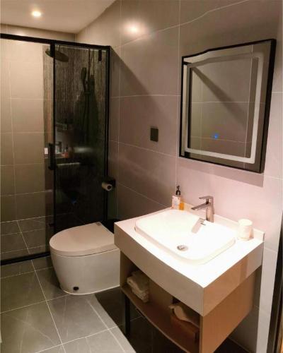 a bathroom with a sink and a toilet and a mirror at GreenTree Inn Datong YundinGYAyuan Express Hotel in Datong