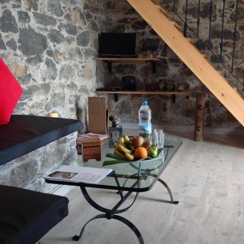 a table with a bowl of fruit and a bottle of water at Fazenda do Sousinha in Funchal