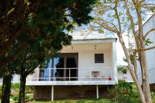 a white house with a balcony and trees at La Maison Dalat in Ấp Man Ling