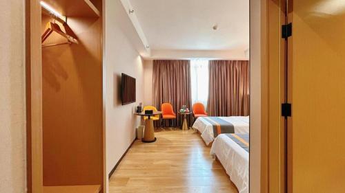 une chambre d'hôtel avec 2 lits et des chaises oranges dans l'établissement GreenTree Inn Shantou Chengjiang Road Business Hotel, à Xialian