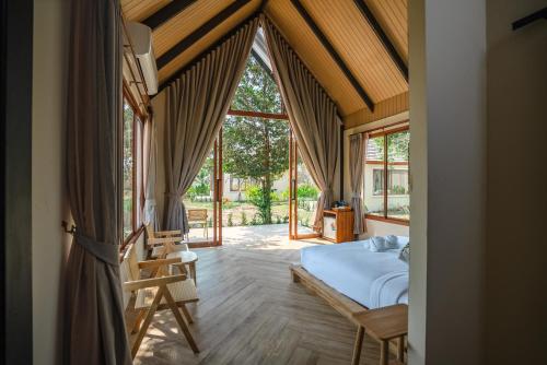 a bedroom with a bed in a room with windows at Moana Resort Koh Kood in Ban Lak Uan