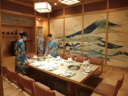 two women in kimonos standing around a table in a restaurant at Shantou Golden Gulf Hotel in Shantou