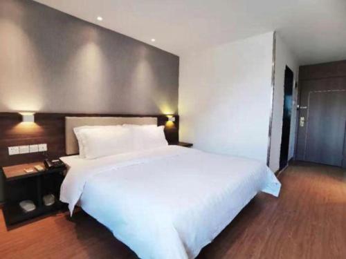 a large white bed in a hotel room with a large bed sidx sidx at 7 Days Inn Guilin Beiji Plaza Yushan Garden in Guilin