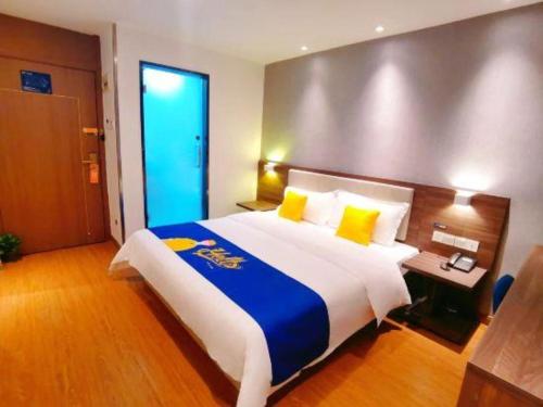a hotel room with a large bed with yellow pillows at 7 Days Inn Guilin Beiji Plaza Yushan Garden in Guilin