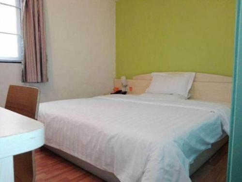 a bedroom with a large white bed in a room at 7 Days Inn Guangzhou Zoo Huanghuagang Metro Station in Guangzhou