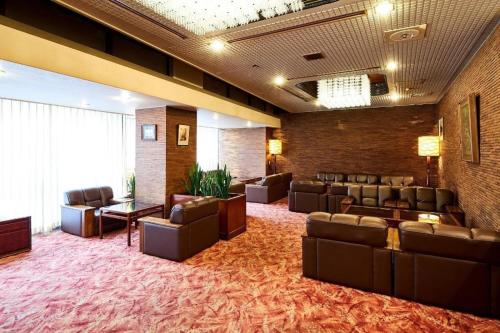 a waiting room with couches and chairs in a building at Marroad Inn Tokyo in Chofu