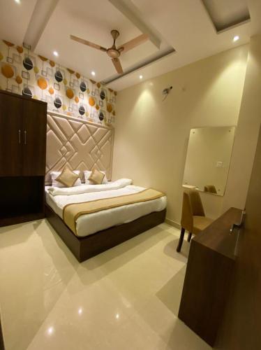 a bedroom with a bed and a dresser and a mirror at Hotel Blossom Inn in Amritsar
