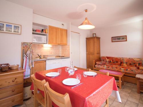 une cuisine et une salle à manger avec une table et des chaises rouges dans l'établissement Appartement confortable 3/4 pers à Aussois - FR-1-508B-18, à Aussois