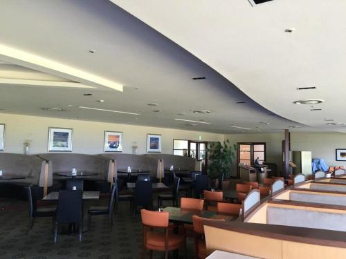 a restaurant with tables and chairs in a room at Hotel Harvest Nankitanabe in Tanabe
