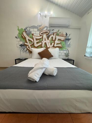 a bedroom with a large bed with a peace sign on the wall at L'urban street Cayenne in Cayenne