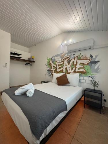 a bedroom with a large bed with a peace sign on the wall at L'urban street Cayenne in Cayenne
