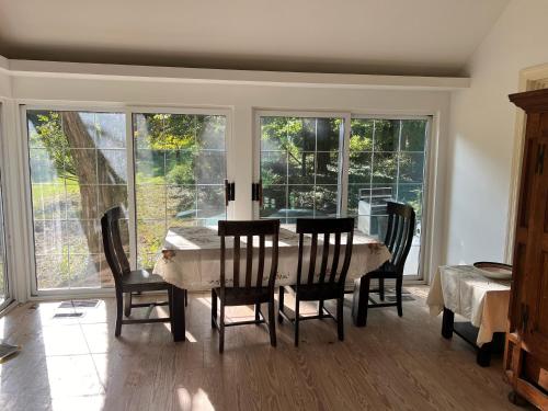 a dining room with a table and chairs and windows at Walnut in Owings Mills