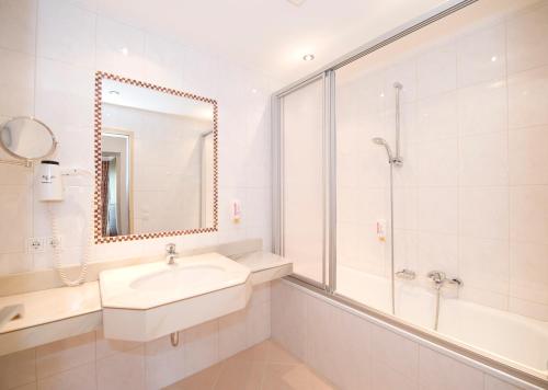 a white bathroom with a sink and a shower at Appartement Hanneshof in Filzmoos