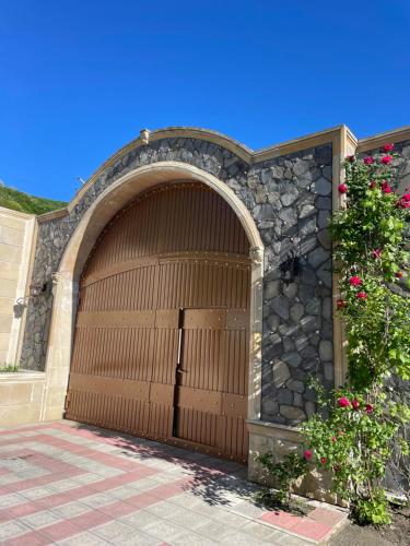a large wooden garage door with a stone wall at Museum Boutique Luxury GH in Sheki