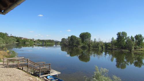 a view of a river with two benches on it at Vila Sunce Morovic in Morović
