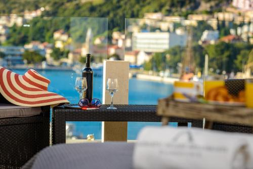a table with a bottle of wine and a hat and glasses at Adriatic Deluxe Apartments in Dubrovnik