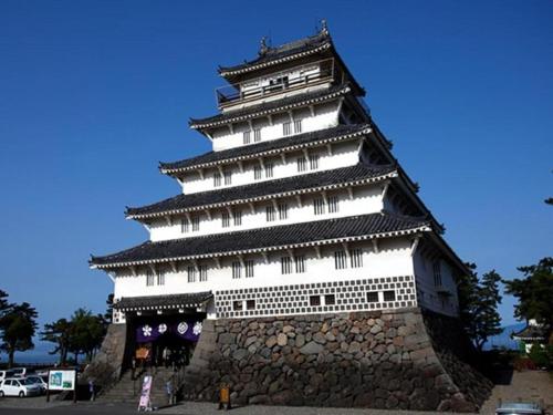 a large white and black tower with a stone wall at Hamakan Hotel in Unzen