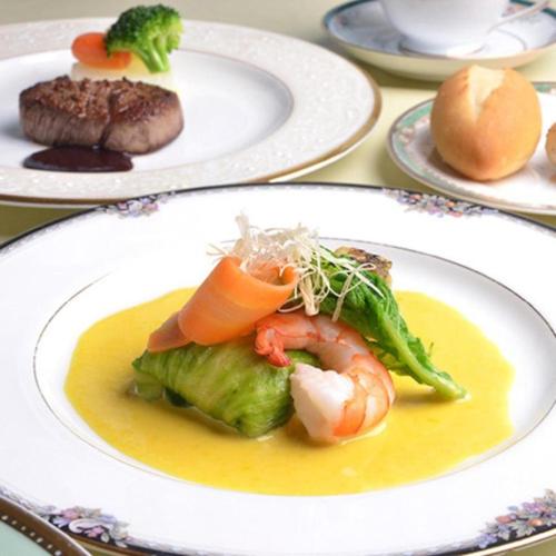 a plate of food with shrimp and broccoli on a table at Hamakan Hotel in Unzen