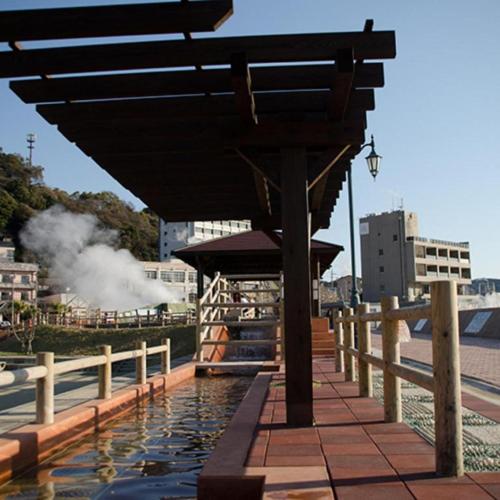 a building with a pool of water next to a fence at Hamakan Hotel in Unzen