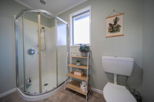 un bagno con doccia e WC di Relaxing Kiwi Bach - Te Anau Holiday Home a Te Anau