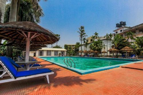 una piscina con sedie e un ombrellone di Siddhartha Hotel Narayangarh a Sauraha
