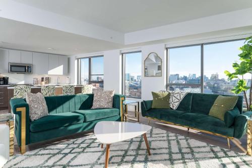 a living room with two green couches and a table at Central Balance Life Work Play in Cambridge
