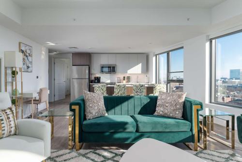 a living room with a green couch and a kitchen at Central Balance Life Work Play in Cambridge