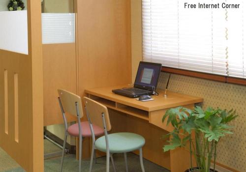 an office with a desk with a laptop and two chairs at Yuzawa New Otani in Yuzawa