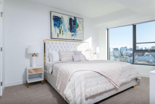 a white bedroom with a large bed and a window at Central Balance Life Work Play in Cambridge