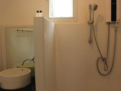 a white bathroom with a shower and a sink at SP. Place Hotel in Ko Chang