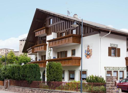 a large white building with wooden balconies on it at Pension an der Mayenburg in Vollan