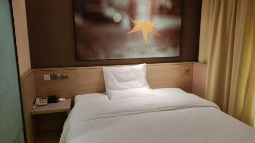 a bedroom with a white bed with a star above it at 7 Days Inn Zhangjiakou Chongli Yuxing Road in Zhangjiakou