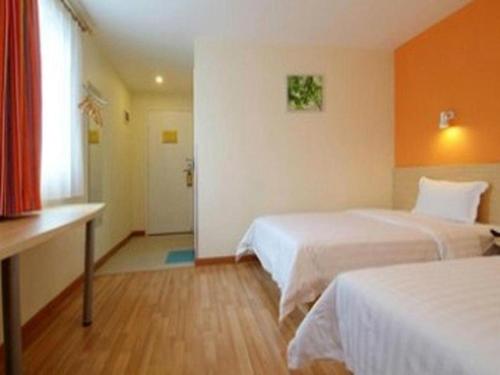 a hotel room with two beds and a window at 7 Days Inn Yiyang Shengli Road in Shangrao