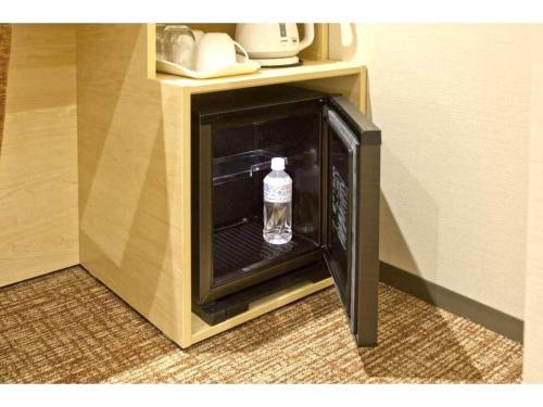 a bottle of water sitting inside of a mini refrigerator at KEIKYU EX INN Keikyu Kawasaki-Station in Kawasaki