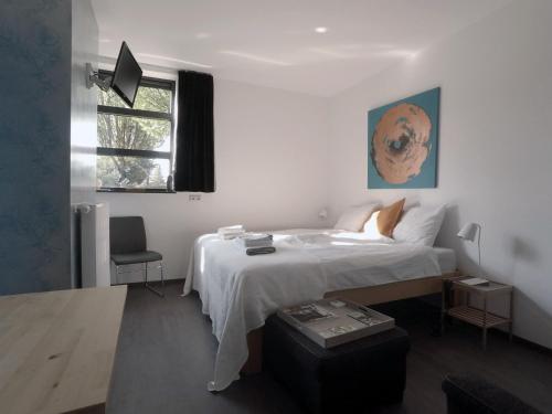 - une chambre blanche avec un lit et une fenêtre dans l'établissement Het blauwe huis, à Reuver