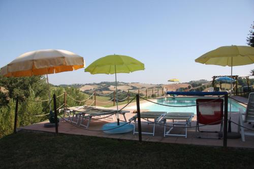 a pool with umbrellas and chairs and a slide at Country House Montesoffio in Barchi