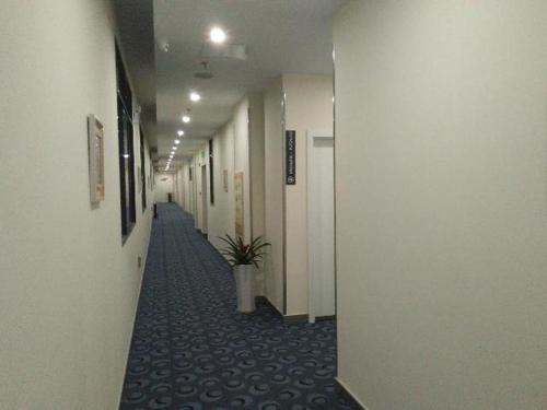 a hallway of an office building with a potted plant at 7 Days Inn Suzhou Wangting Pearl Commercial Plaza in Suzhou