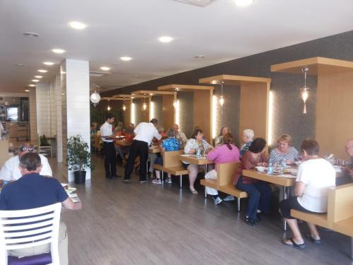 a group of people sitting at tables in a restaurant at Enar Hotel in Kırıkkale