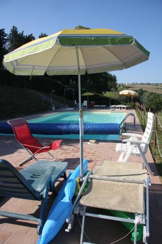 an umbrella and chairs next to a swimming pool at Country House Montesoffio in Barchi
