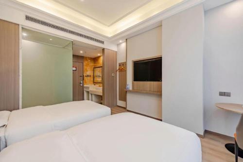 a hotel room with two beds and a flat screen tv at GreenTree Alliance Anhui Hefei South Passenger Station South High Speed Railway Station Hotel in Hefei
