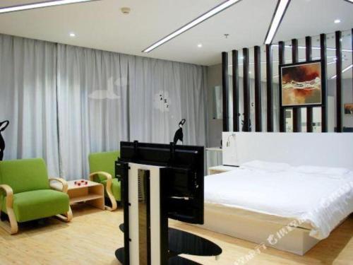 - une chambre avec un lit, une télévision et des chaises dans l'établissement 7 Days Inn Qinhuangdao Changjiang Road Chinese Medicine Hospital Branch, à Qinhuangdao