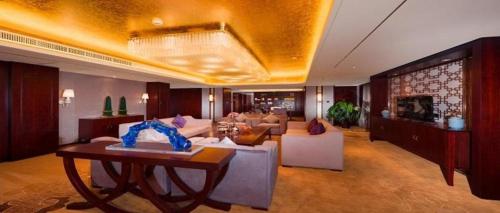 a living room with a couch and a table at New Century Grand Hotel Xi'an Xizang Building in Xi'an