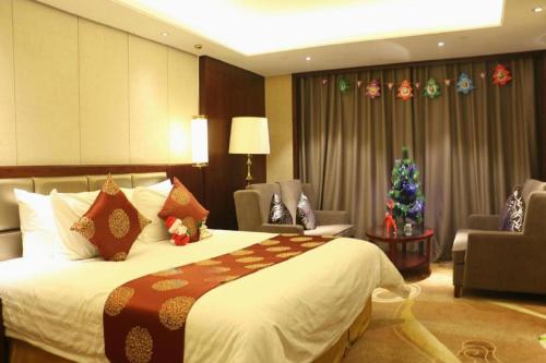 a hotel room with a bed and a christmas tree at New Century Grand Hotel Xi'an Xizang Building in Xi'an